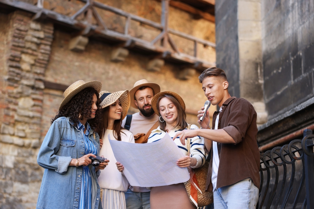 Guide,With,Microphone,And,Group,Of,Tourists,On,City,Street