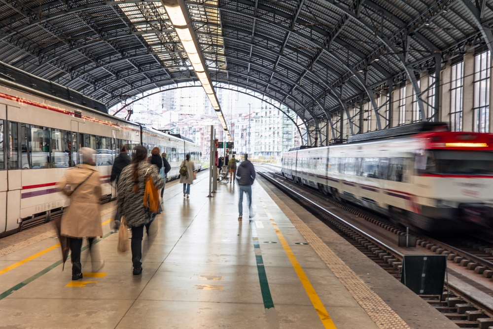 Pasajeros,caminando,por,el,andén,de,una,estación,de,tren,con