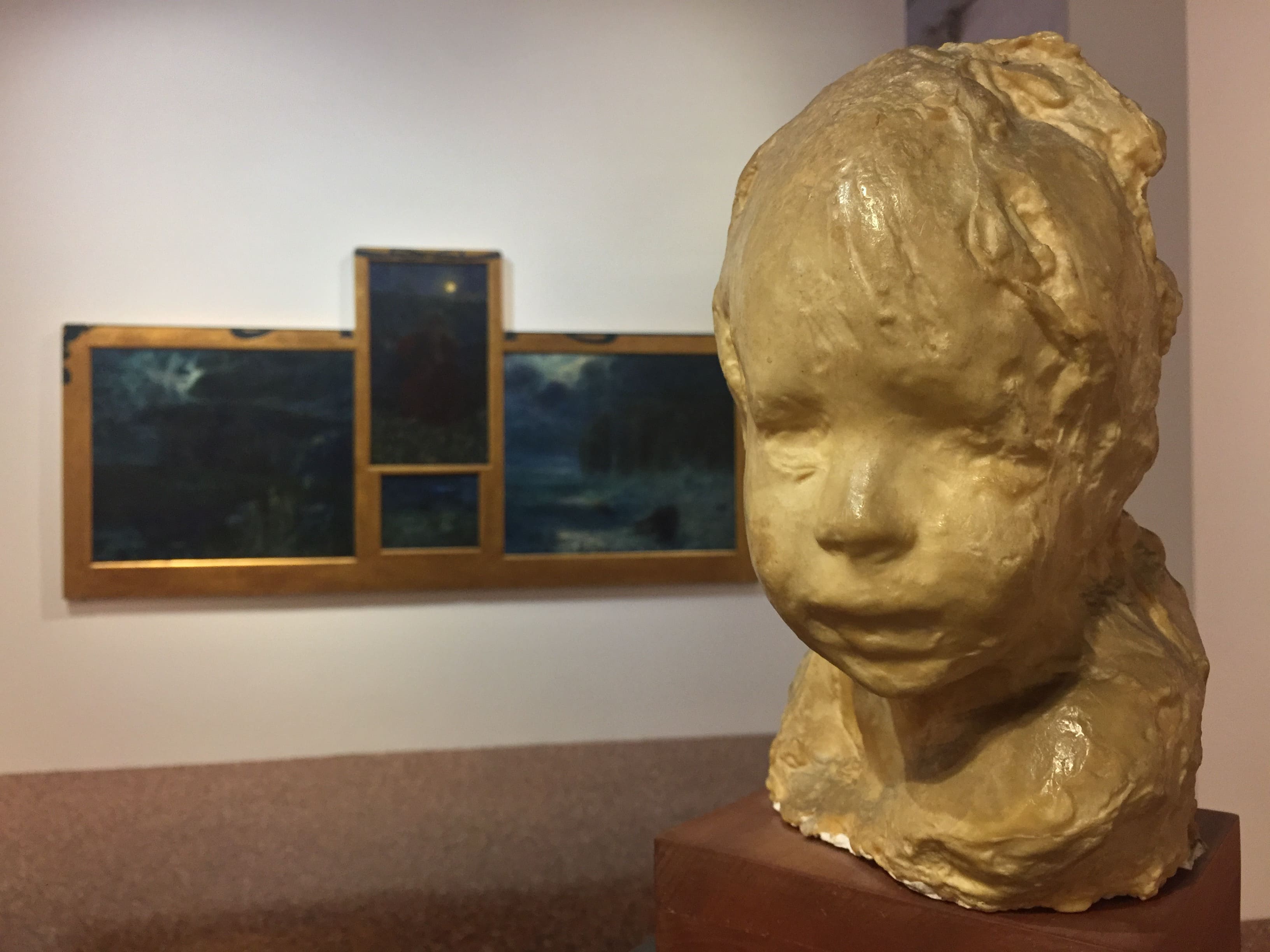 ca-pesaro-escultura de busto de niño con fondo de tríptico