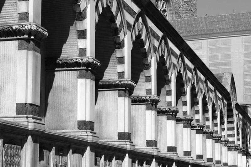 Detail of the lateral arches in perspective in white marble of the famous church of Santa Maria Novella in Florence Italy, black and white photograph